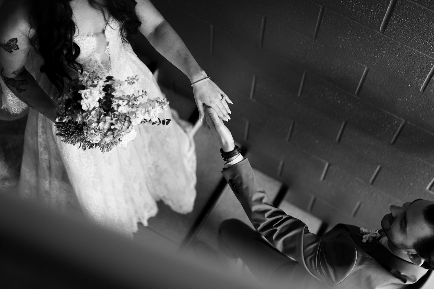Bride and groom holding hands on the stairs