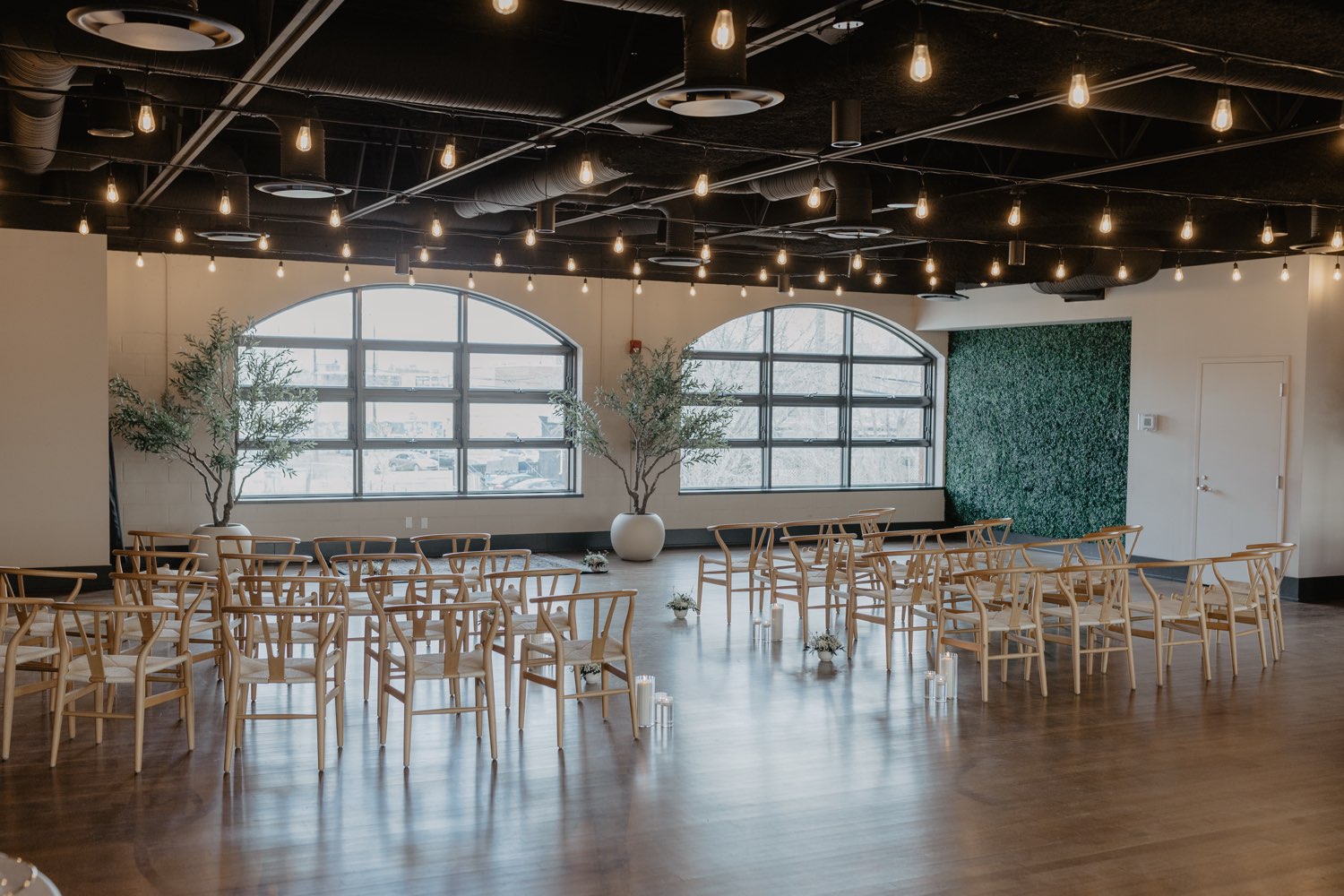 Ceremony set with greenery wall and olive trees