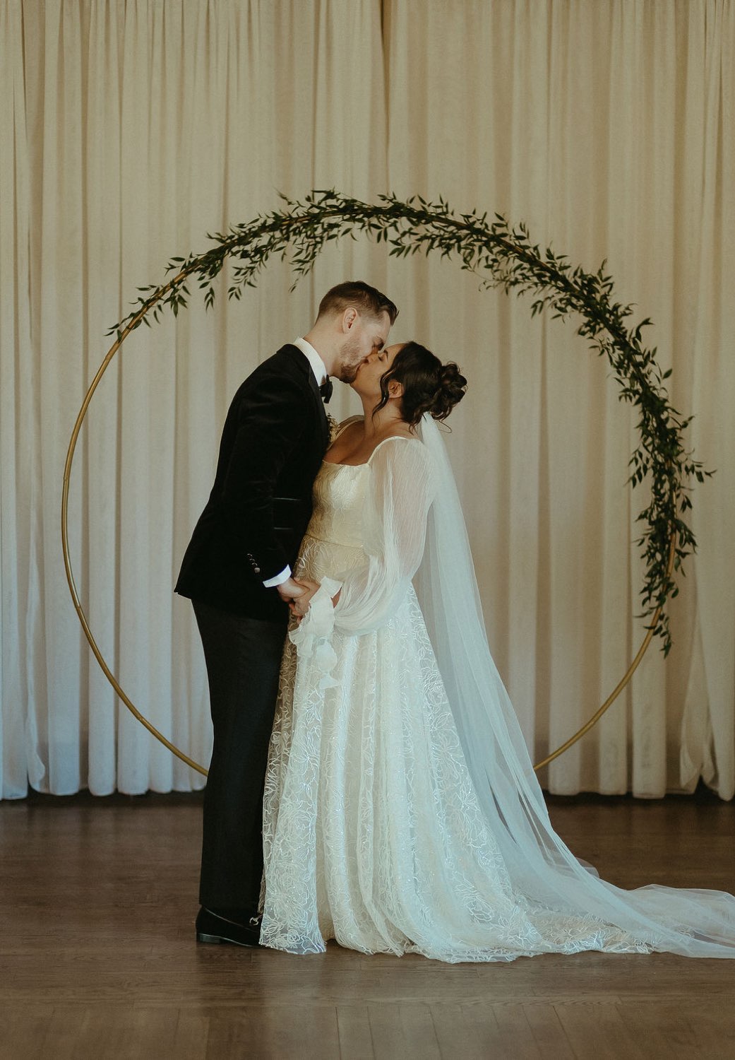 First kiss beneath the greenery arch