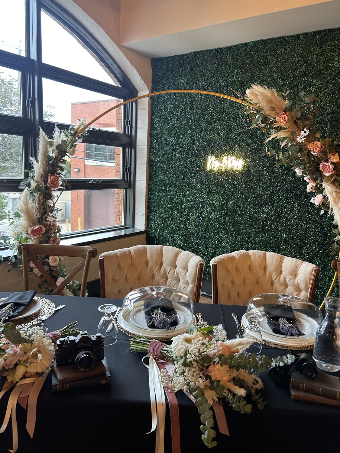 Sweetheart table with greenery wall and neon sign